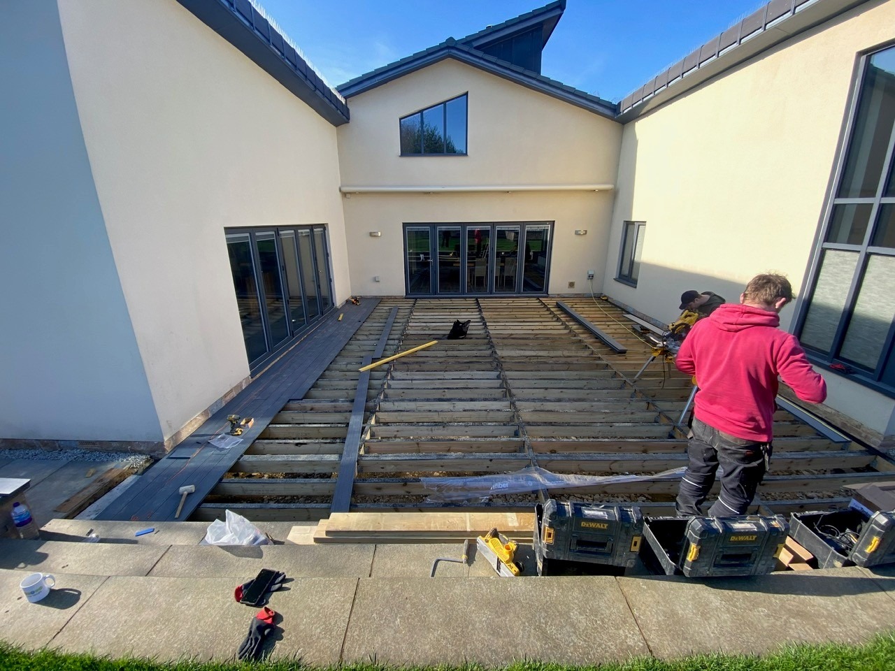 Composite decking boards being installed on large rear terrace