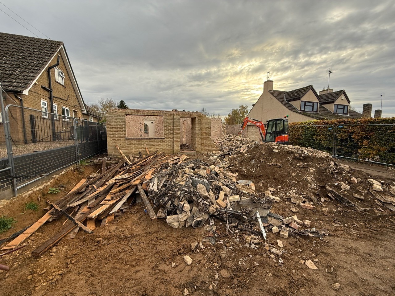 Demolition of existing house to make way for new build with excavator on site