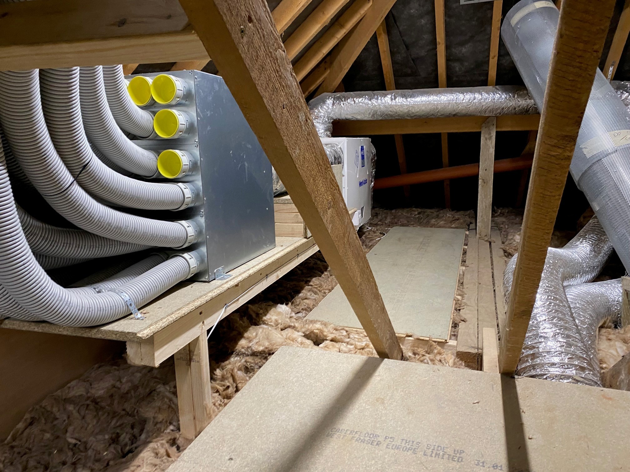 MVHR ventilation unit with ductwork installed in loft space