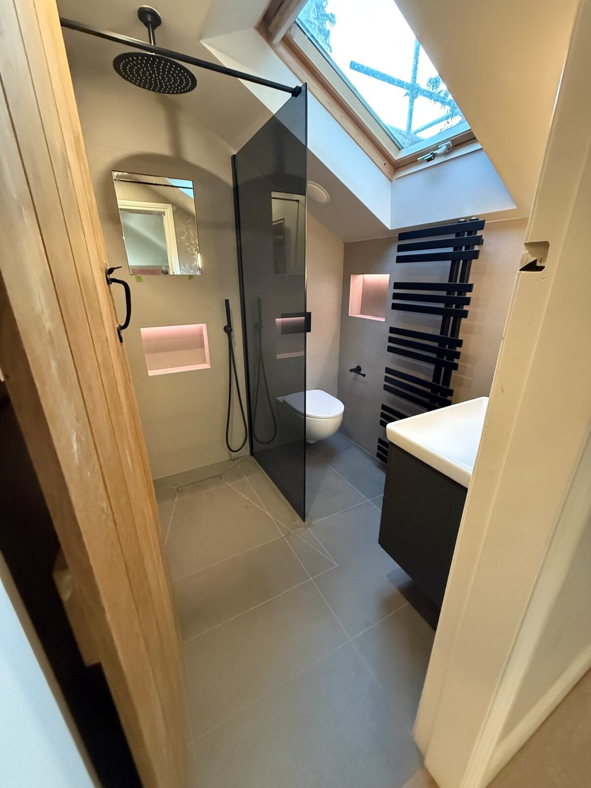 Loft bathroom with black fixtures and Velux