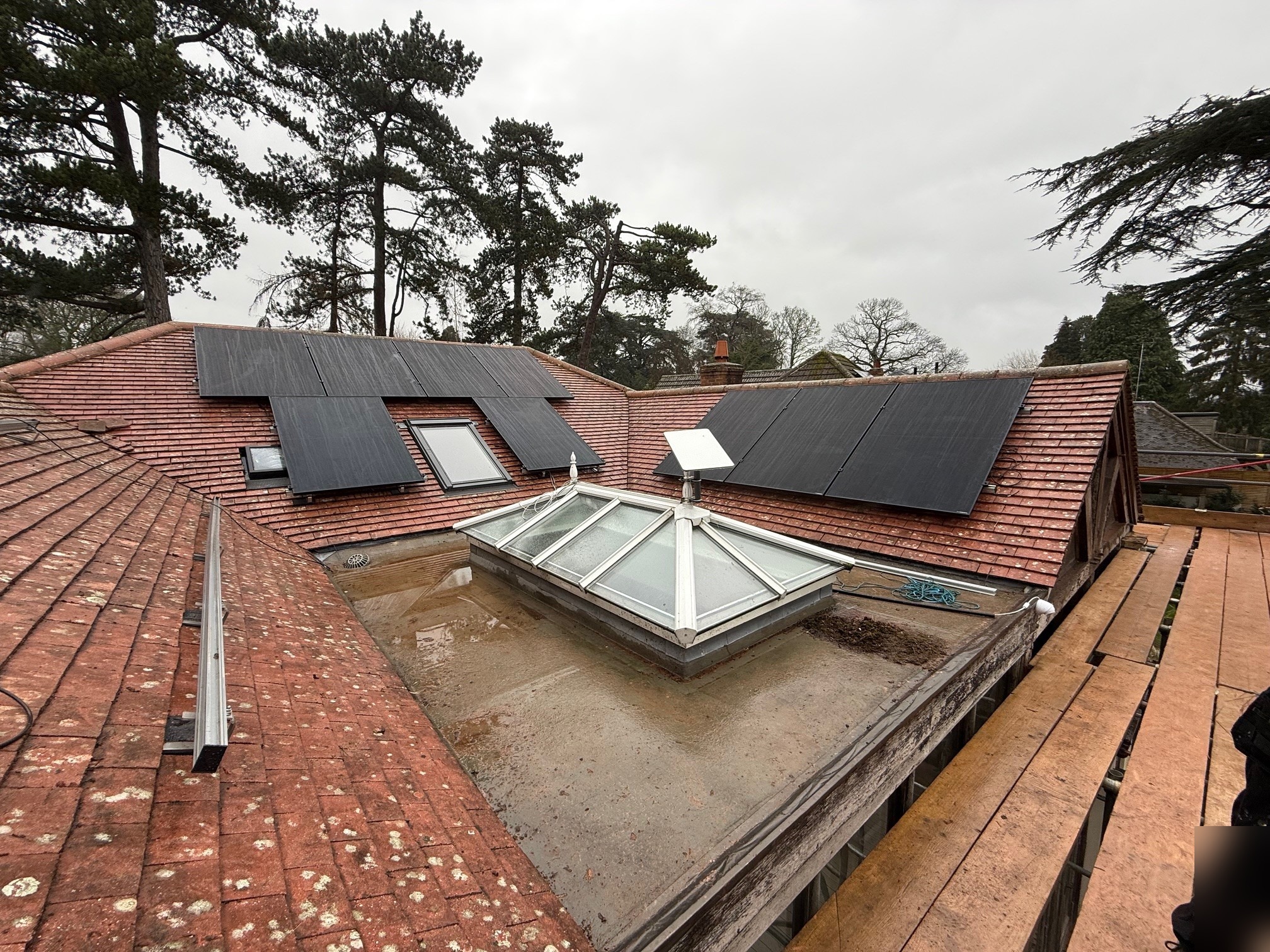 Solar panels across multiple roof pitches on large residential property with roof lantern